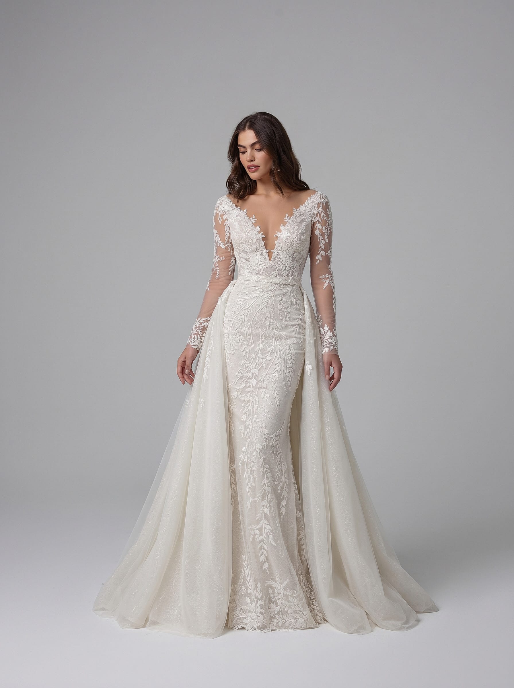 Mermaid wedding dress in floral beaded lace with deep V-neckline, long illusion sleeves, open back and detachable tulle overskirt